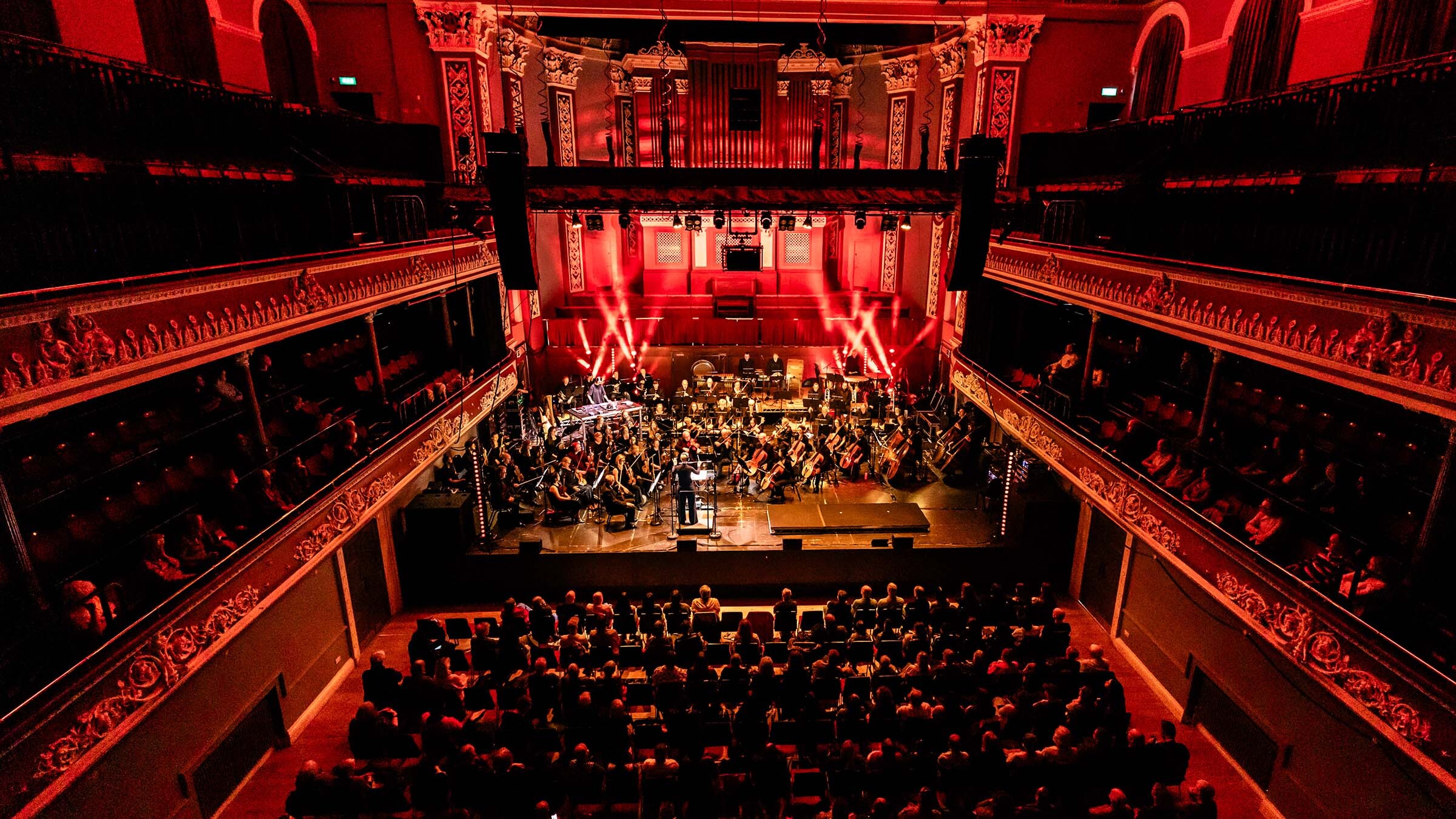 Venue with orchestra and crowd